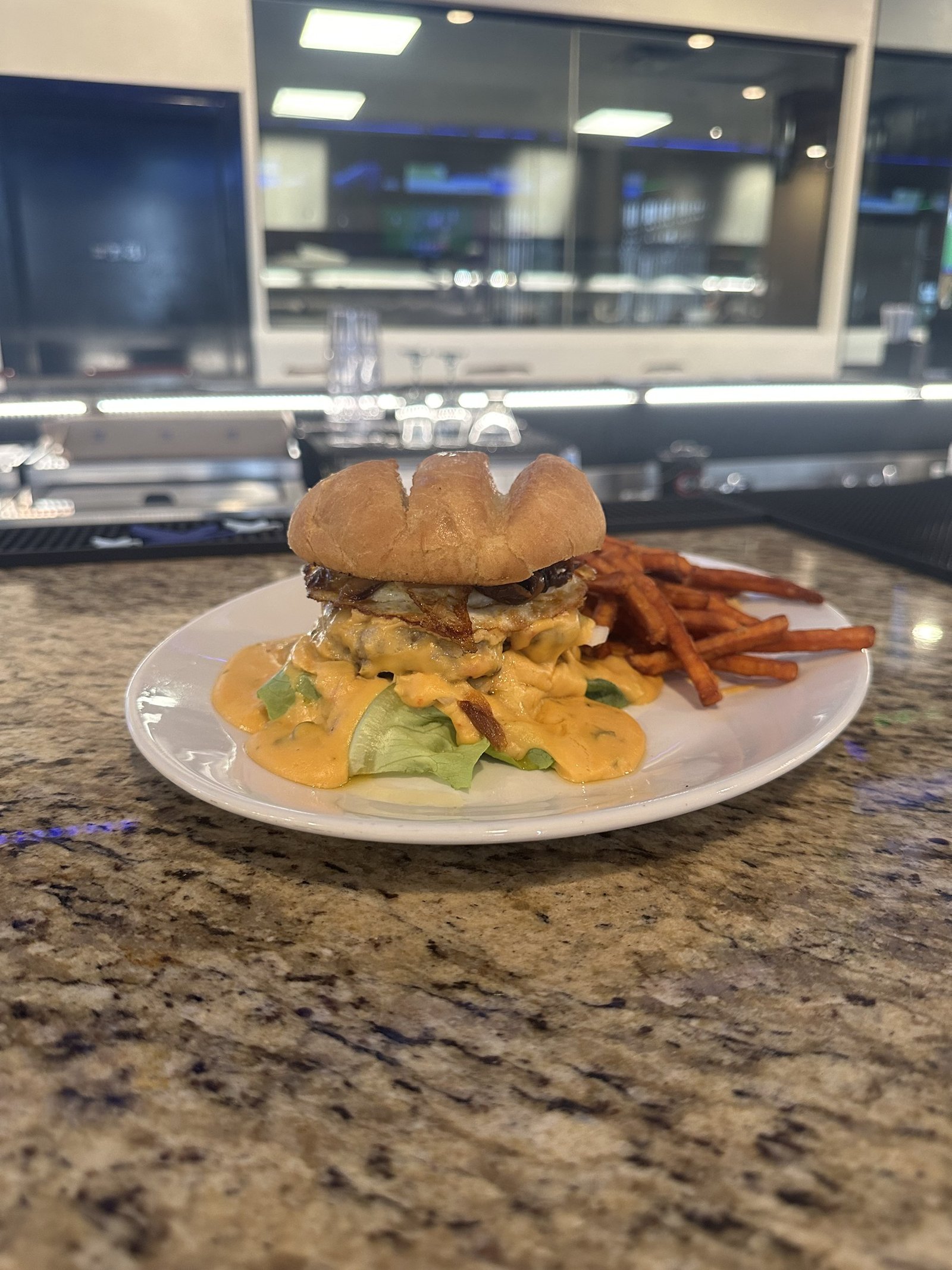 The Miami burger with queso, a fried egg and sweet potato fries at Border Burger Sports Bar