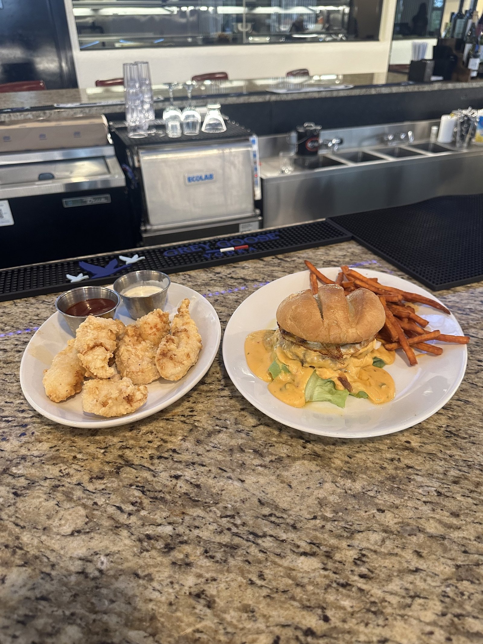 Red Bird chicken strips and the Miami burger with sweet potato fries on the bar at Border Burger Sports Bar