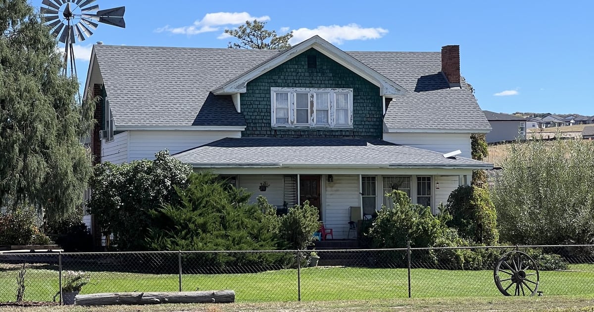 The Lowell family's green-trimmed ranch house and windmill behind the pond at CALF's Lowell Ranch in Castle Rock