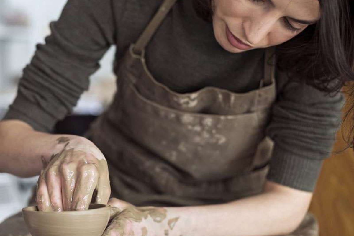 Student shaping a vase in a pottery class at the Cantril School Building