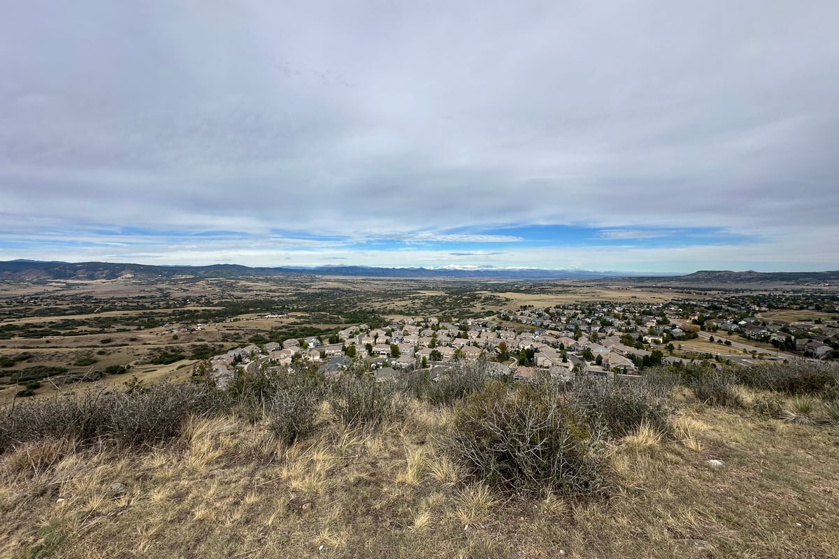 Rooftops of a Castle Rock neighborhood on the west side, with the Front Range beyond, seen from a trail at Miller Park