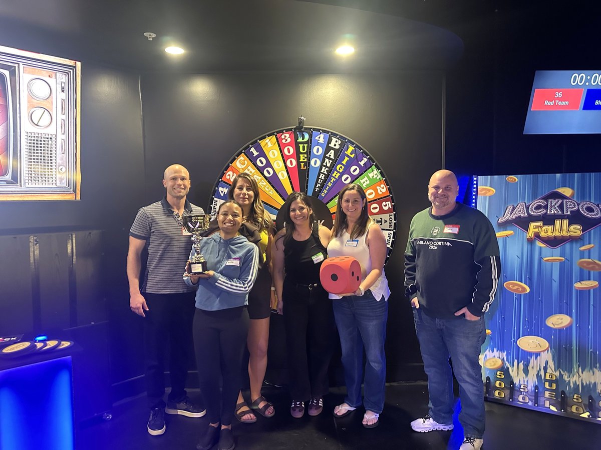 The winning team with the trophy and the giant foam duel die