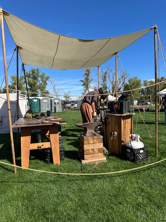 The blacksmith's forge and anvil under a canvas awning at the Colorado Highland Games