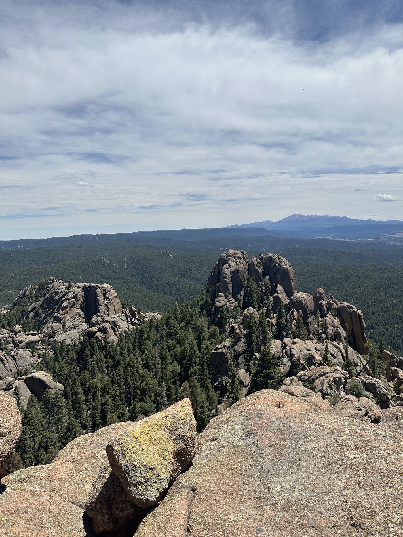 View south from the top of Devils Head across granite formations and Pike National Forest, with Pikes Peak on the horizon