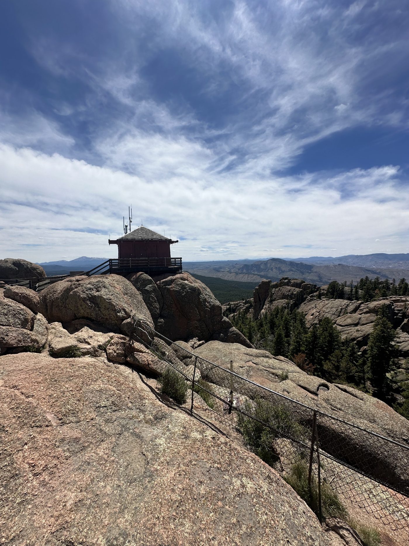 The Devils Head fire lookout tower perched on granite against a blue Colorado sky