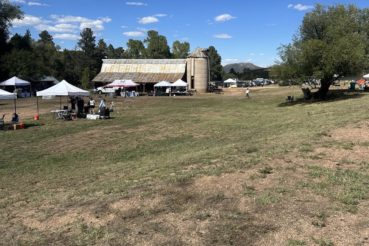 Festival tents on the meadow in front of the barn at Sandstone Ranch