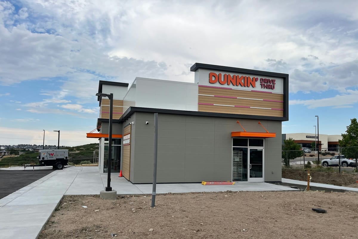 Corner view of the Dunkin' building at Founders Marketplace with landscaping still unfinished