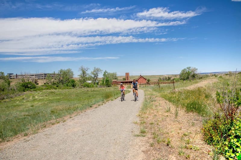 Cyclists on the gravel East/West Regional Trail through grassland