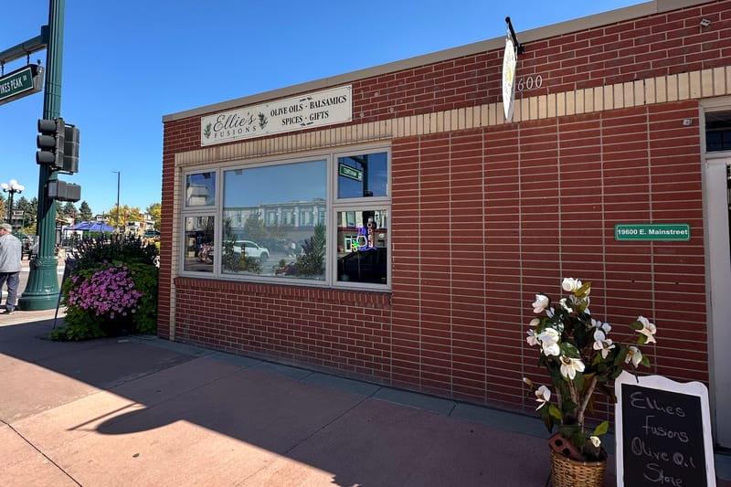 The Ellie's Fusions storefront at 19600 E Mainstreet in downtown Parker, Colorado, with its olive oils, balsamics, spices and gifts sign and address plaque