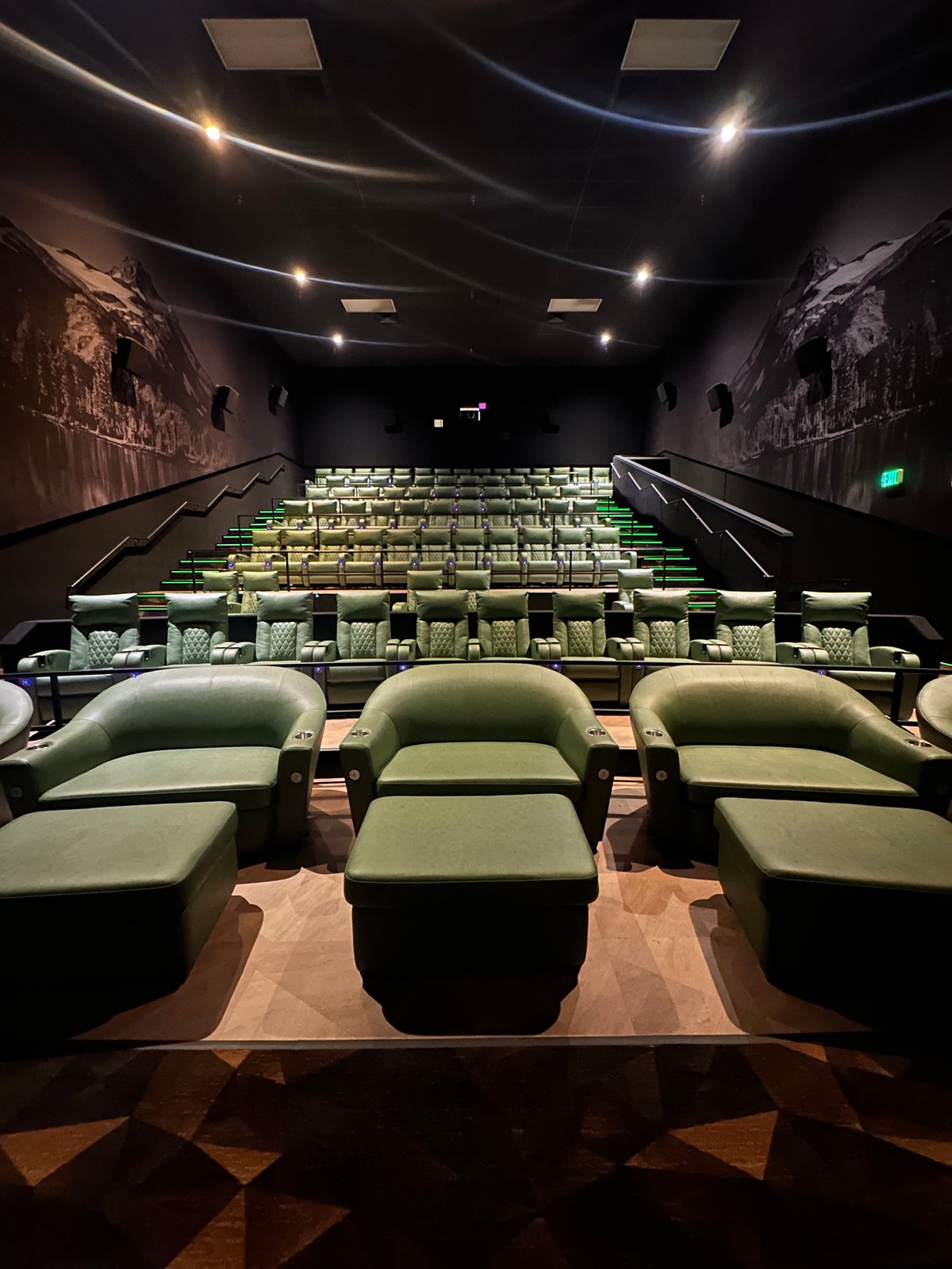 An Emagine Parker auditorium with a Colorado mountain landscape mural running across the ceiling above the recliner rows.