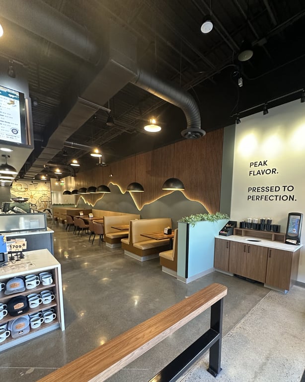 Inside Griddled at the Outlets at Castle Rock — the "Peak Flavor, Pressed to Perfection" mountain wall and booth seating