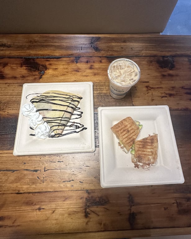 Griddled visit spread — Trailblazer panini, Nutella mascarpone strawberry crêpe, and a dulce de leche iced latte on the table