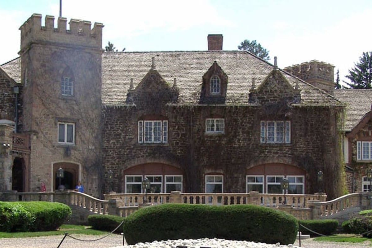 The stone front of the Highlands Ranch Mansion with its castle-style tower, balustrade and lawn