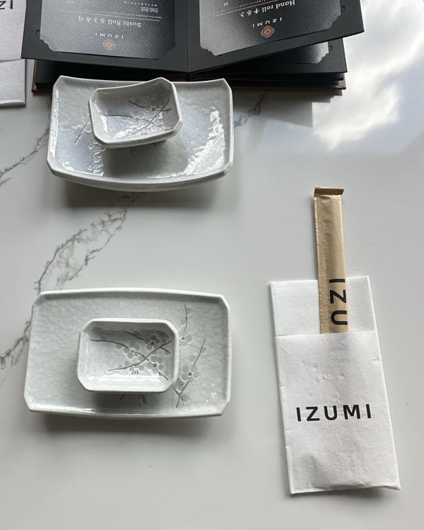 Izumi Sushi branded chopsticks, napkin, and ceramic dishes