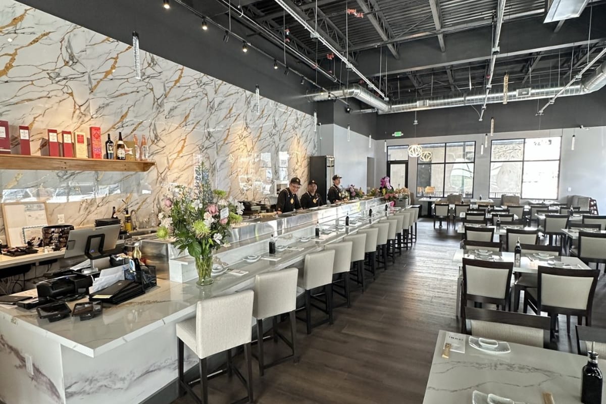 Izumi Sushi dining room with marble waterfall counter and floral arrangement