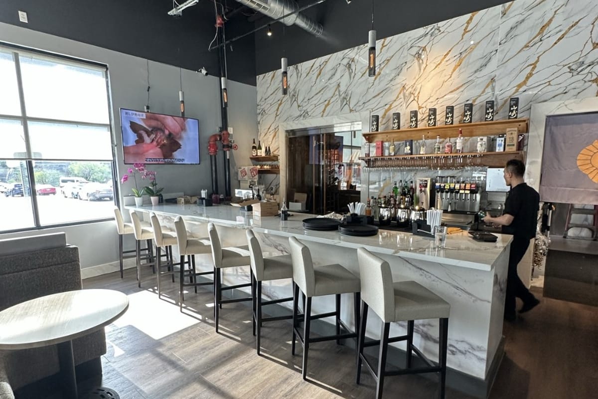Izumi Sushi sushi bar with chef and bottle wall
