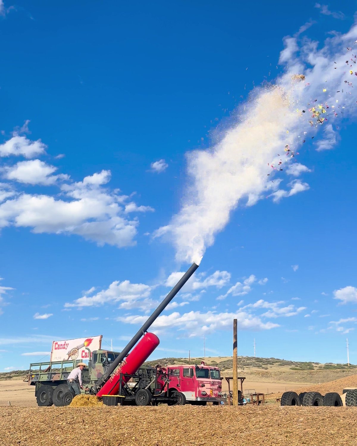 The Candy Cannon firing a plume of candy into a blue sky at Lone Creek Farms