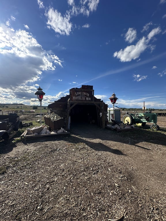 The entrance to the Lone Creek Matchless Mine with lanterns and a green tractor