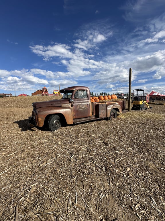 A rusty Lone Creek Farms pickup loaded with pumpkins