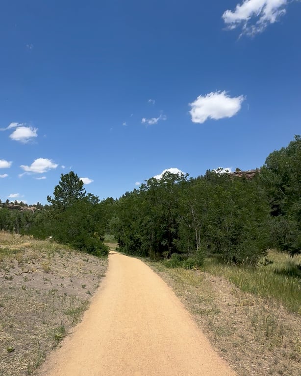 The Willow Creek Path at Lost Canyon Ranch Open Space, a crusher-fines valley trail curving through grassland under a blue sky, Castle Rock