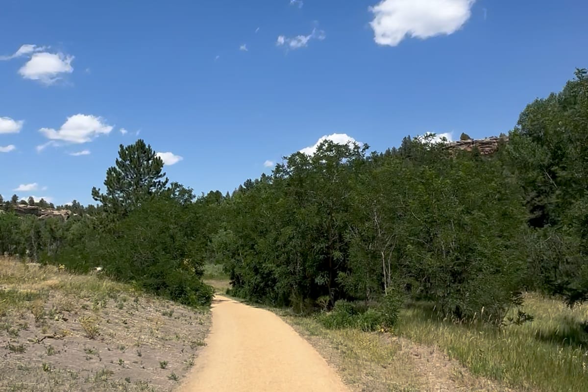 The Willow Creek Path at Lost Canyon Ranch Open Space, a crusher-fines valley trail curving through grassland under a blue sky, Castle Rock