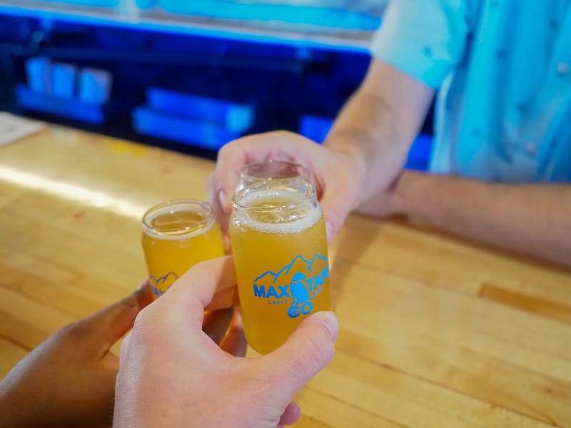 Two beers raised in a toast at the bar at Max Taps in Highlands Ranch