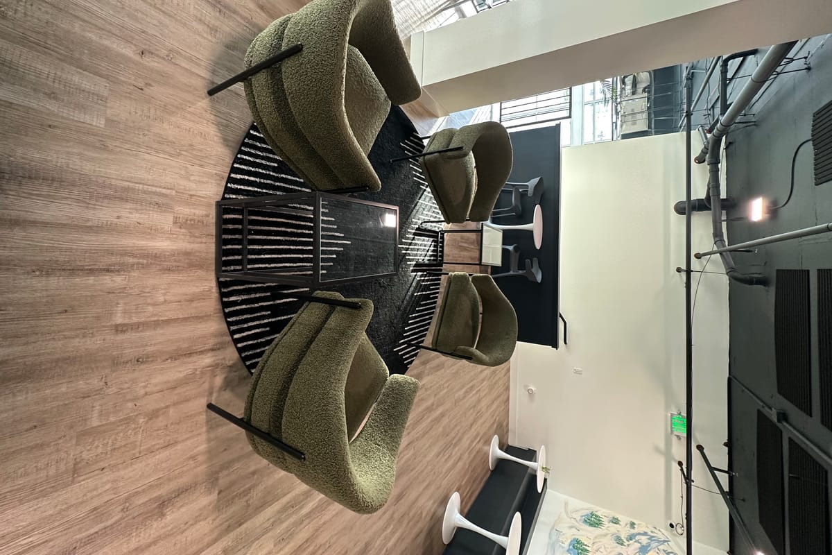 Green boucle lounge chairs around a coffee table on the black-and-white rug at Monk & Mongoose High Note