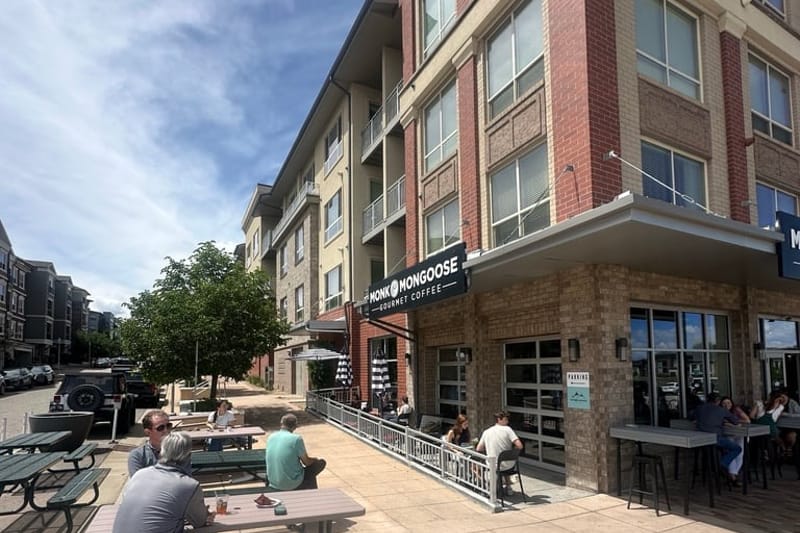 Monk & Mongoose Coffee Co. storefront at RidgeGate Pkwy in Lone Tree, with sidewalk seating out front