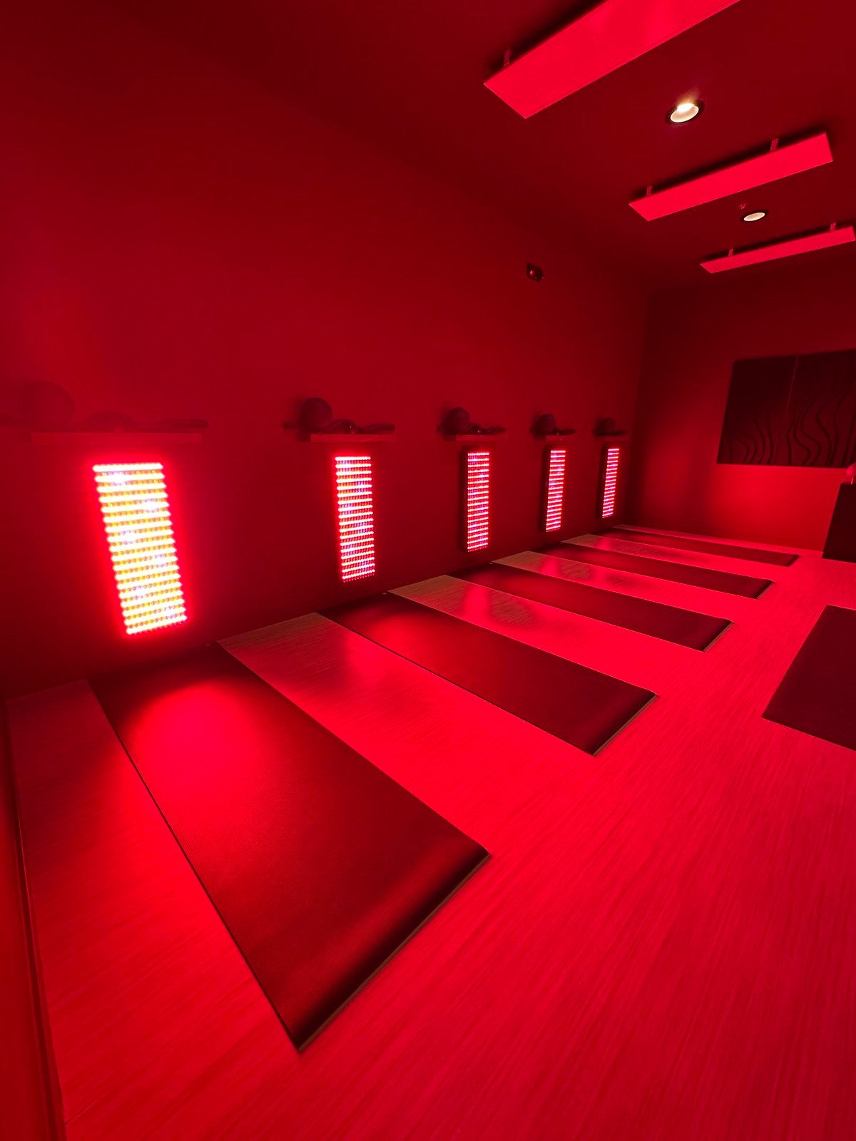 The Glow studio at Nova Glow, red light panels over the mat stations