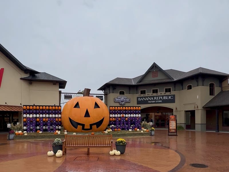Big Jack, the giant jack-o'-lantern, between the pumpkin walls in the Outlets at Castle Rock courtyard, with Banana Republic behind it