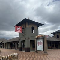 Outlets at Castle Rock clock tower with directory map and storefronts in the background