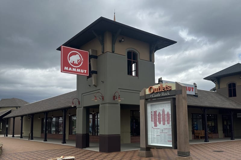 Outlets at Castle Rock clock tower with directory map and storefronts in the background