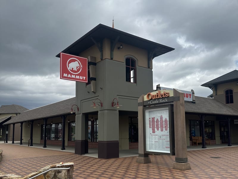 Outlets at Castle Rock clock tower with directory map and storefronts in the background