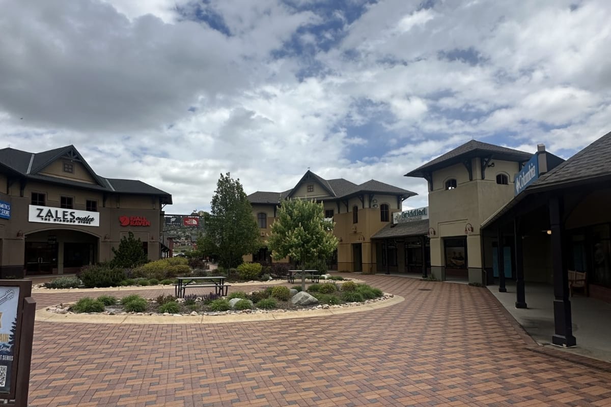 Central courtyard garden circle with Zales storefront and brick walkway at Outlets at Castle Rock