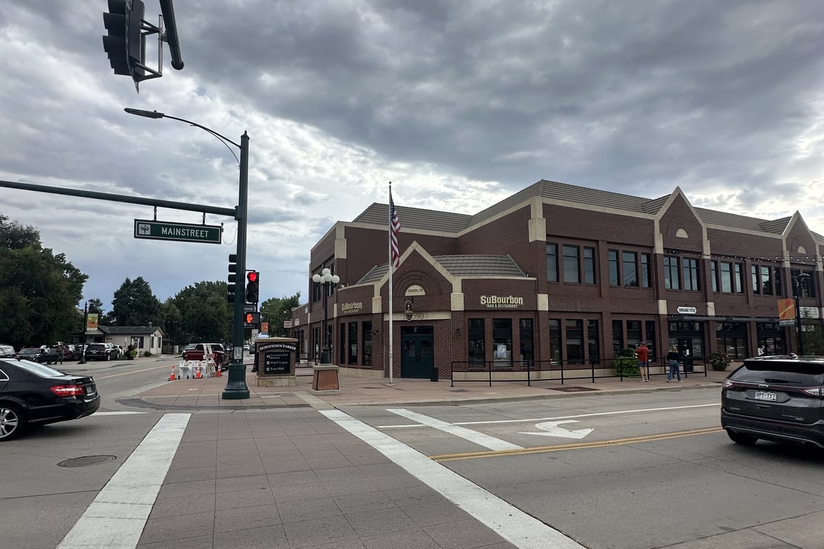 The brick corner building at Mainstreet and Pikes Peak Drive in downtown Parker under a stormy August sky