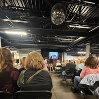 The crowd seated facing the stage and screen at A Night with the Coroner at Pikes Peak Event Center in Parker