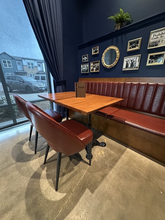 Champagne Velvet Proper Kitchen & Bar booth seating with Prohibition-era gallery wall and gold mirror