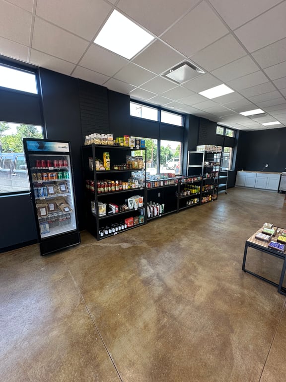The specialty-grocery and provisions shelves — local sauces, pasta, and pantry goods — inside Rugby Scott in downtown Parker