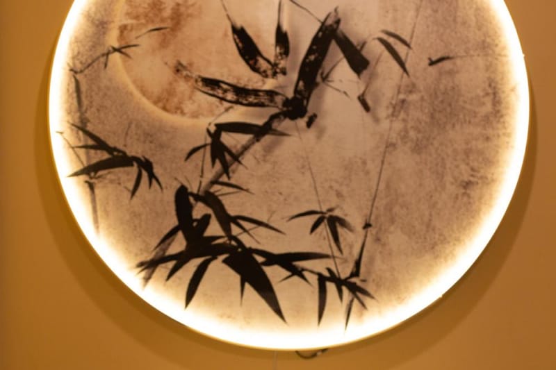 Treatment room with a backlit bamboo moon window at SereniTea Spa & Tea Lounge