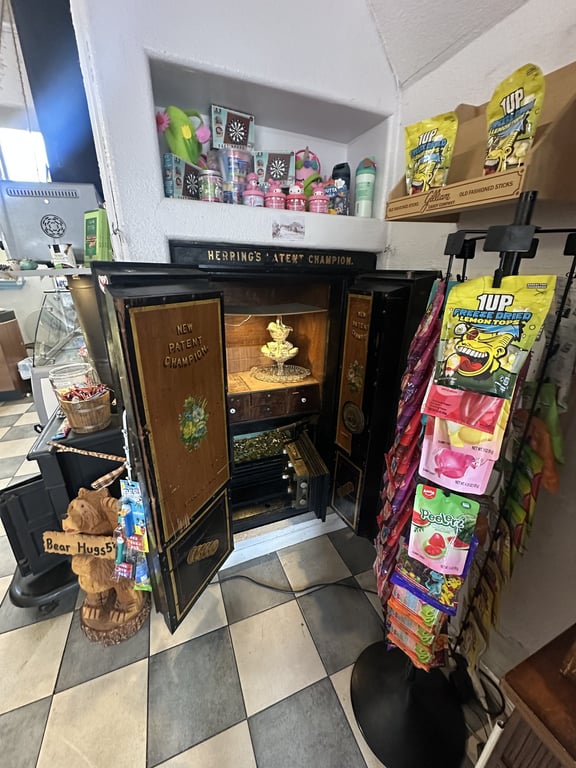 The antique Herring's Patent Champion safe, open against the wall beside the candy racks.