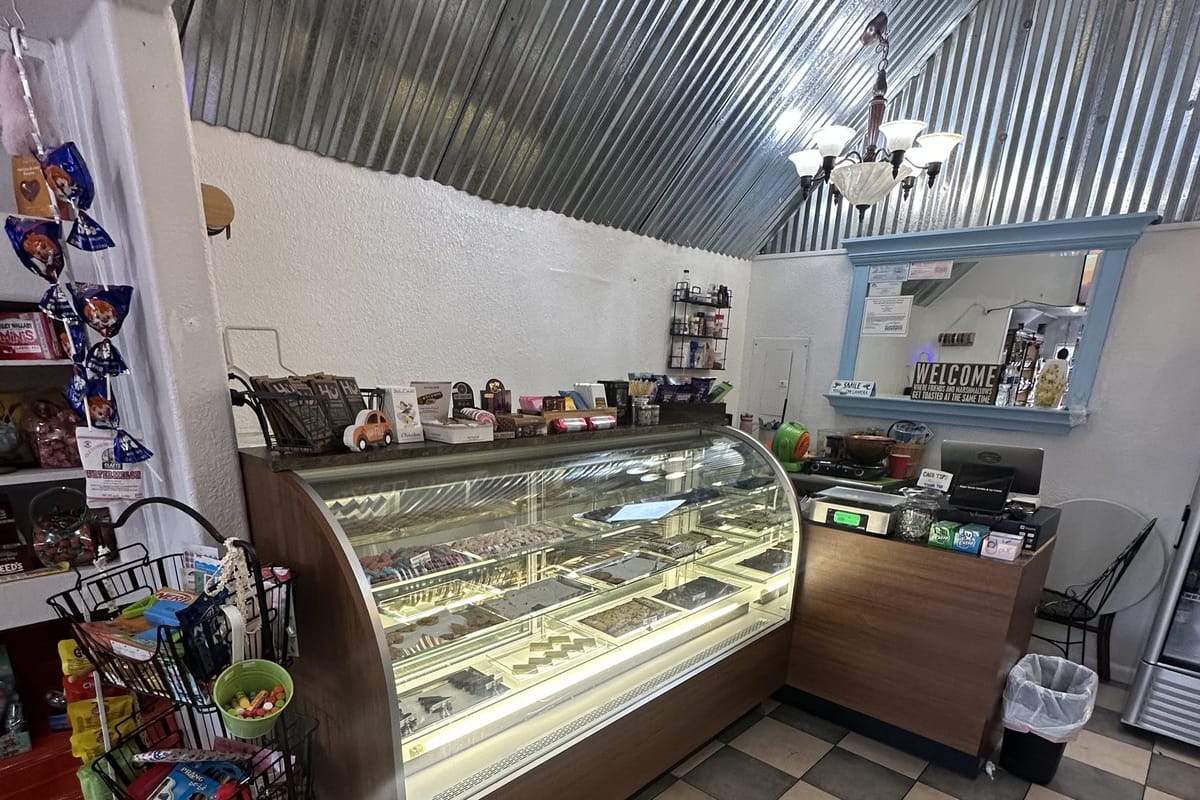 The curved glass case of fudge and hand-dipped chocolates, with the register counter beyond