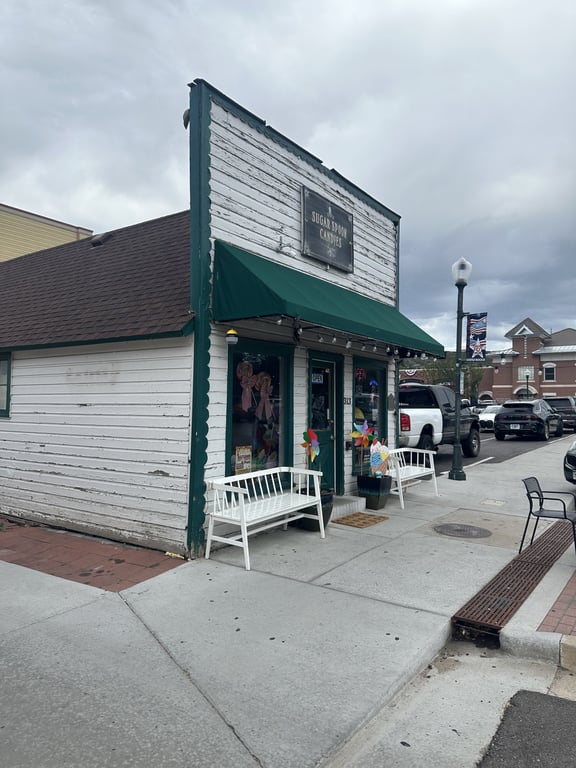 Sugar Spoon Candies at 313 Third St, with its green awning and the benches out front.