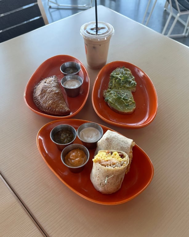 Breakfast spread at The Groove in Lone Tree: breakfast burrito, empanada, avocado toast, and an iced latte