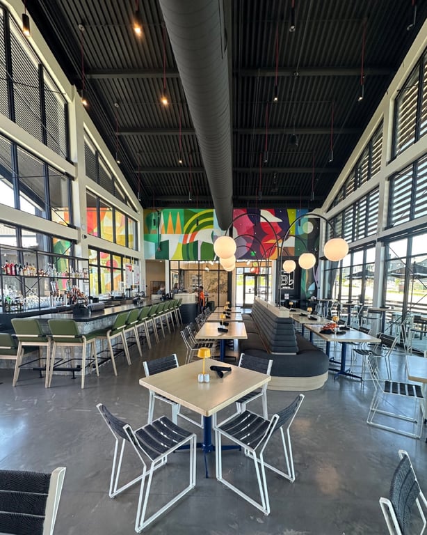 Inside The Groove at Lyric: green banquette bar, the 60-foot Magik Studios mural, and floor-to-ceiling windows