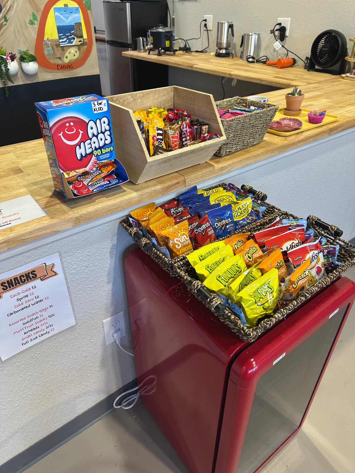The snack counter at The Hot Spot Studios in Castle Rock, stocked with sodas, chips, and candy next to a printed price list
