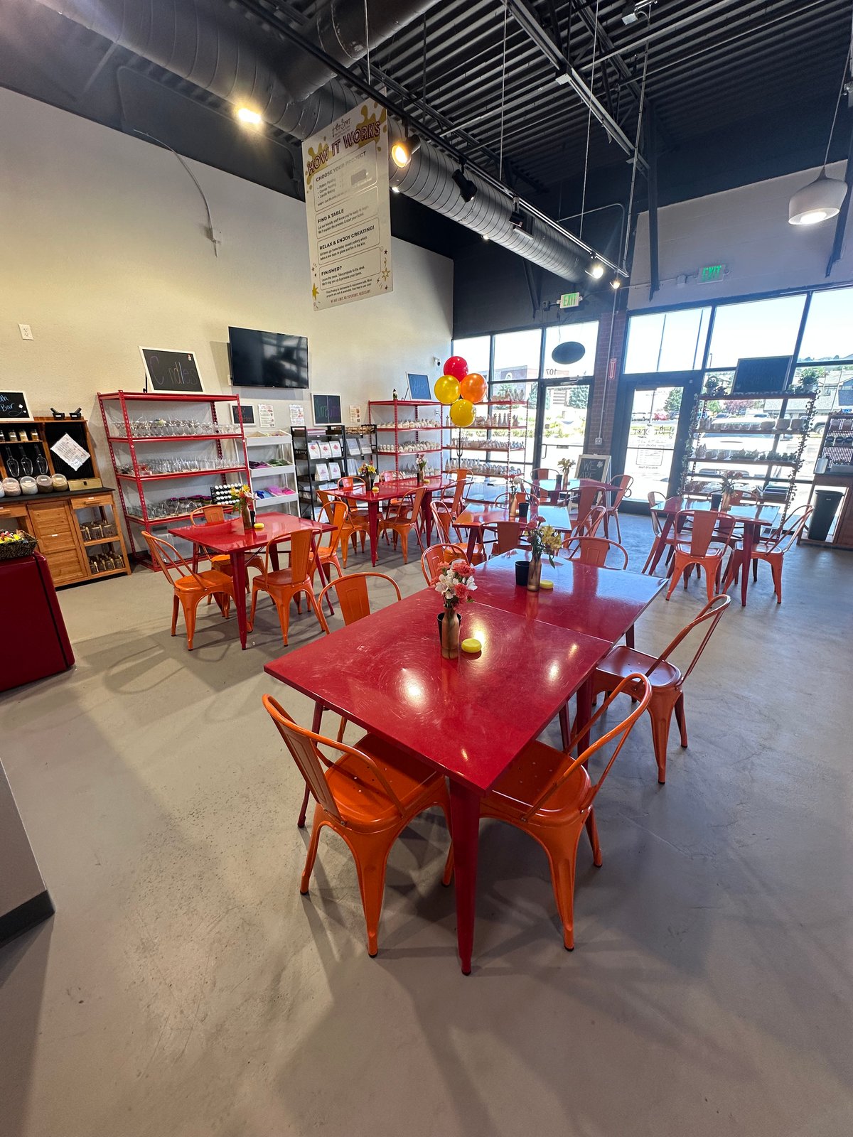 Colorful interior seating with red tables and orange chairs at The Hot Spot Studios in Castle Rock