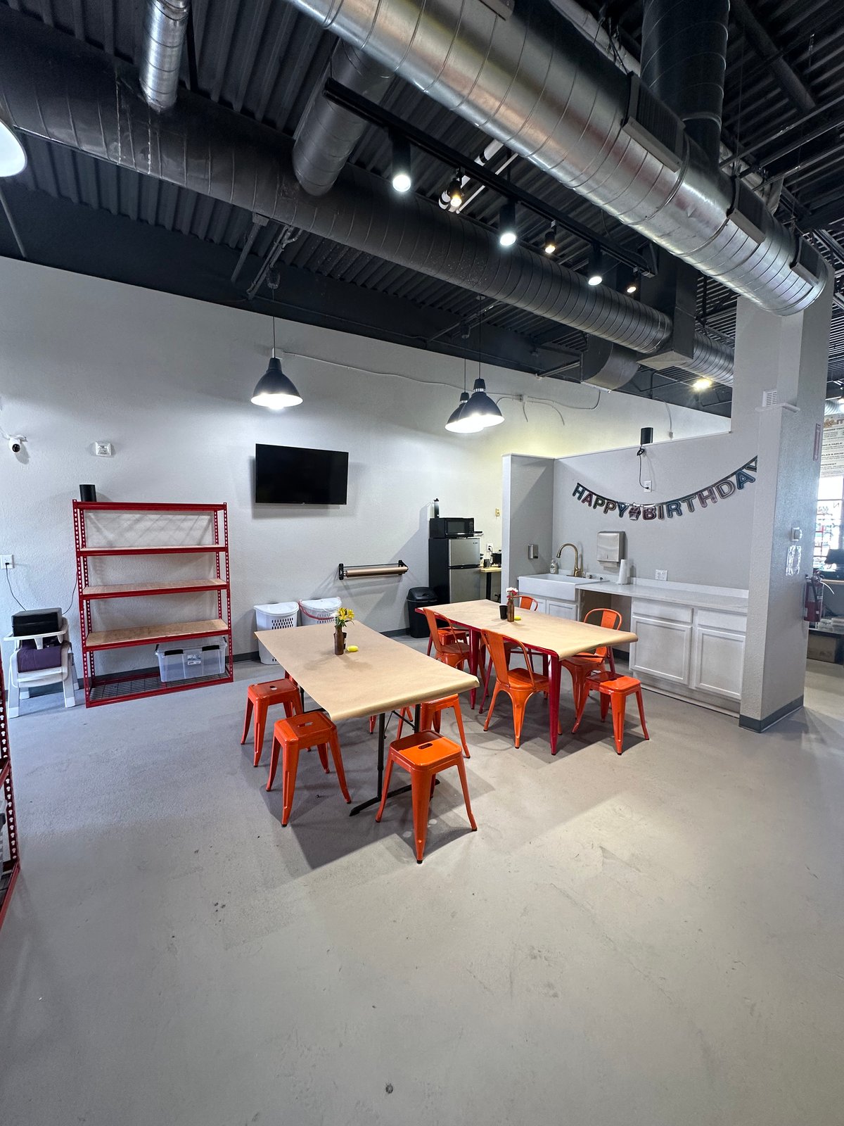 The private party room at The Hot Spot Studios in Castle Rock, with worktables, a TV, and a birthday banner