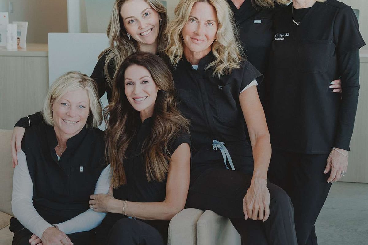 The Skin Company team gathered in front of the reception sign