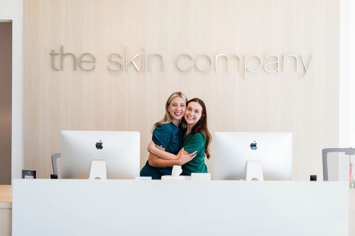 Two Skin Company staff members behind the front desk