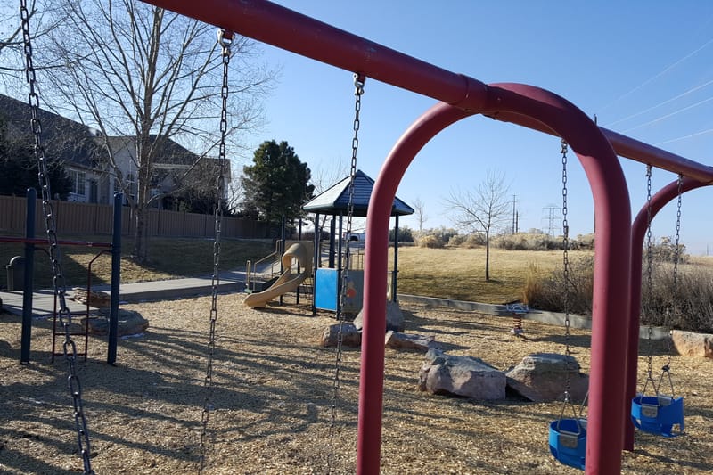 Swings and the playground at Daniels Gate Park in Castle Pines
